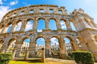 Römisches Amphitheater in Pula, sonniger Tag, blauer Himmel, antike Architektur.